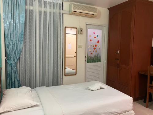 a bedroom with a bed and a window and a mirror at MD House in Chiang Mai