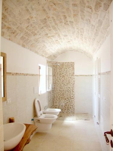 a bathroom with two sinks and a toilet in a room at Masseria Signora in Martina Franca
