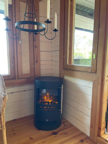 a wood burning stove in a room with a window at Villa Valkeinen in Nilsiä