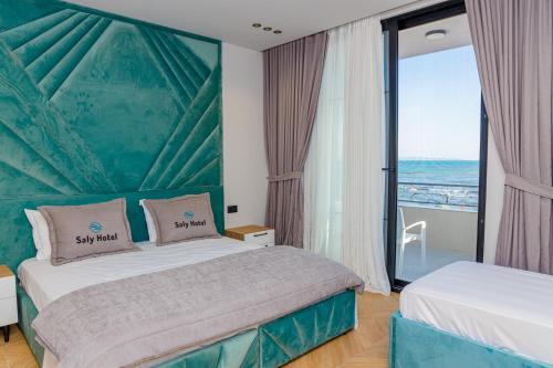 a hotel room with a bed with a view of the ocean at Hotel Saly in Durrës