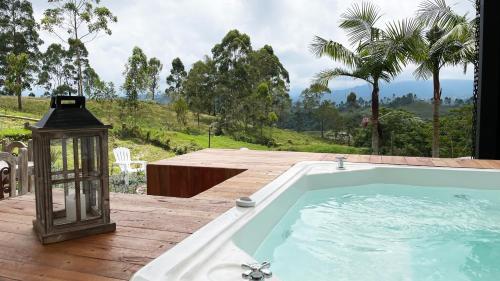 eine Whirlpool-Badewanne auf einer Terrasse mit Laterne in der Unterkunft Aguas Claras Luxury Hospedaje in Filandia