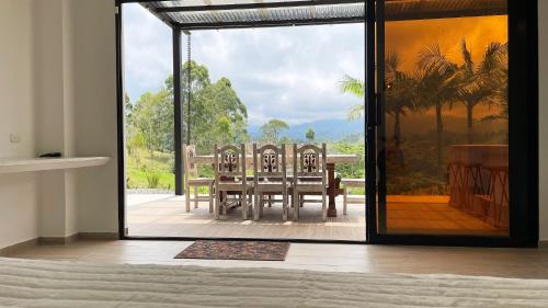 a room with a table and chairs on a patio at Aguas Claras Luxury Hospedaje in Filandia