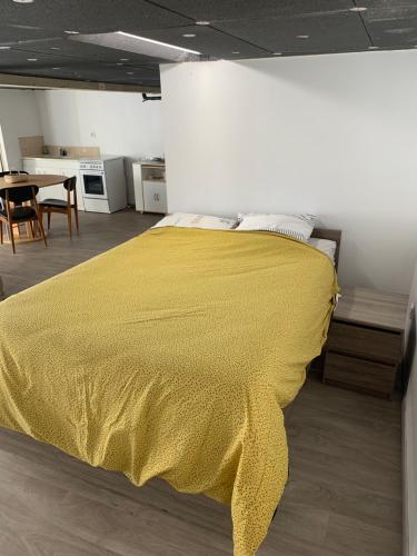 a bedroom with a yellow blanket on a bed at Le_QG_Meymanais in Beauregard-Baret