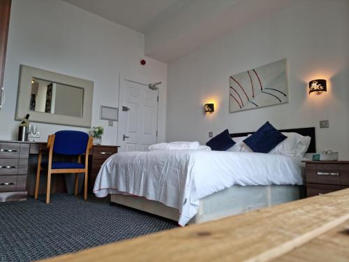 a bedroom with a bed and a desk and a mirror at The Queen Vic Hotel in Monkwearmouth