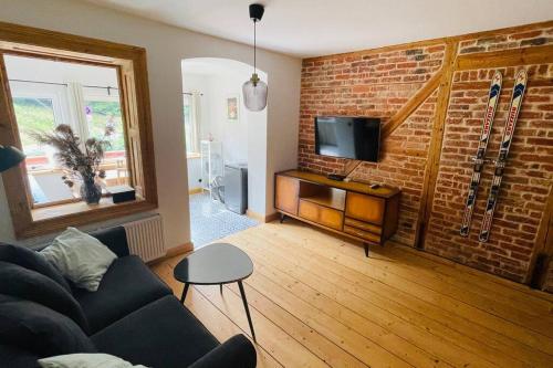 ein Wohnzimmer mit einer Couch und einer Ziegelwand in der Unterkunft U Babci Marysi in Karpacz