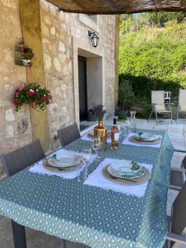 - une table avec des assiettes et des verres à vin sur la terrasse dans l'établissement Maison Campagne Aixoise, à Éguilles