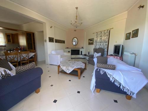 a living room with two couches and a table at Thalatta and Oros Traditional Villa in Tyros