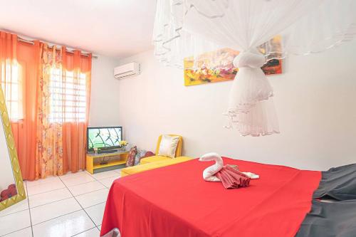 a bedroom with a red table with a dress hanging on the wall at Villa paradisiaque à Pointe-Noire avec piscine privée in Pointe-Noire