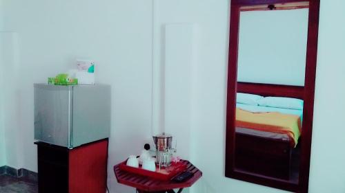 a bedroom with a bed and a mirror at Home Stay Resort in Nilaveli