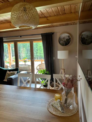 una sala de estar con una mesa con un jarrón de flores en GRABNIK55, en Krasnobród