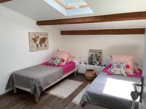 une chambre avec deux lits et une lucarne dans l'établissement Maison Campagne Aixoise, à Éguilles