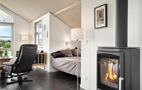 Zimmer mit einem Kamin, einem Bett und einem Stuhl in der Unterkunft 4 Bedroom Cozy Home In Hadsund in Hadsund