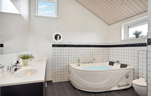 ein Badezimmer mit einer Badewanne, einem Waschbecken und einem WC in der Unterkunft 4 Bedroom Cozy Home In Hadsund in Hadsund