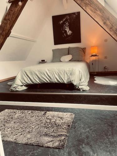 ein Schlafzimmer mit einem Bett im Dachgeschoss in der Unterkunft L idylle de Guillaume in Falaise