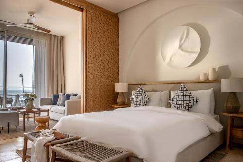 ein Schlafzimmer mit einem großen weißen Bett und ein Wohnzimmer in der Unterkunft Yalikavak Marina Hotel By Social Living Collection in Yalıkavak