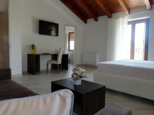 a living room with a bed and a table with flowers at Il Riccio home & relax in Riccia