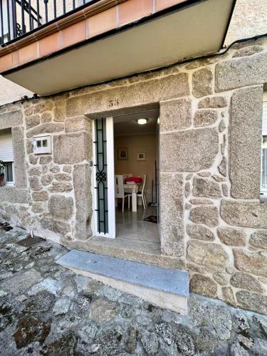 a door to a stone building with a table in it at La casita de la abuela María in Navalacruz