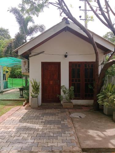 a small white house with a red door at Home Stay Resort in Nilaveli