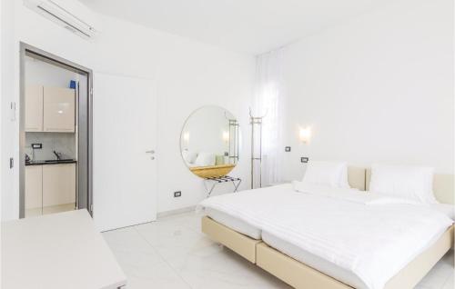 a white bedroom with a large bed and a mirror at Gorgeous Apartment In Funtana With Outdoor Swimming Pool in Funtana