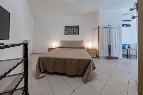 a bedroom with a bed and a television in it at H11 [Bussana 1A] Mare in Bussana Nuova