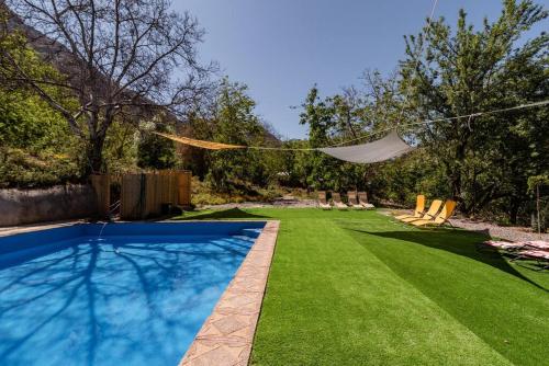a backyard with a swimming pool and green grass at Cabaña Jacuzzi Exterior Privado in San José de Maipo