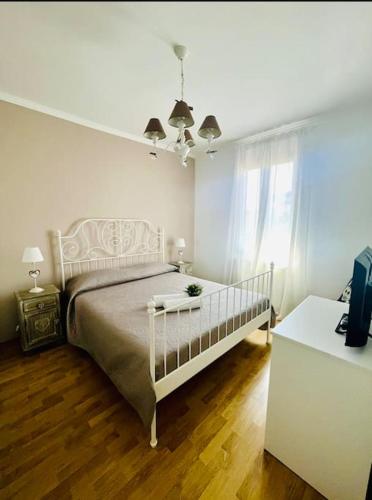 a white bedroom with a bed and a window at Civico 22 in Fiumicino