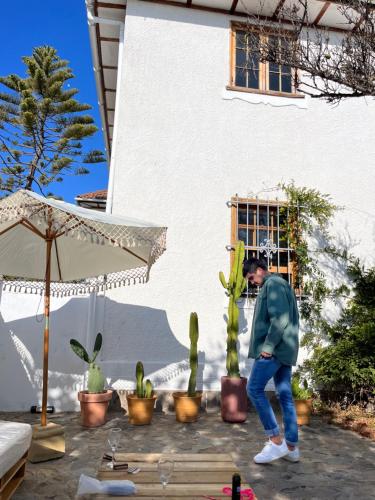 a man is standing next to a cactus at La Posada Coliving in Viña del Mar