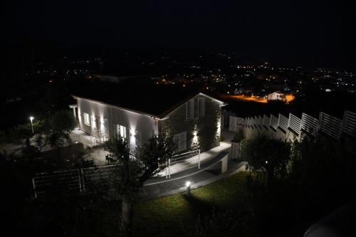 una casa bianca con luci accese di notte di Tenuta Del Duca a Marina di Casalvelino