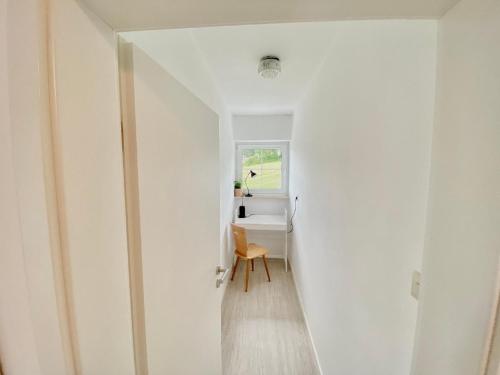 a hallway with a chair and a desk in a room at Ferienwohnung Lusenhöh in Mauth
