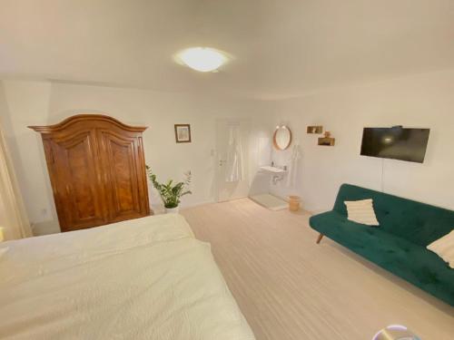 a bedroom with a bed and a green couch at Ferienwohnung Lusenhöh in Mauth
