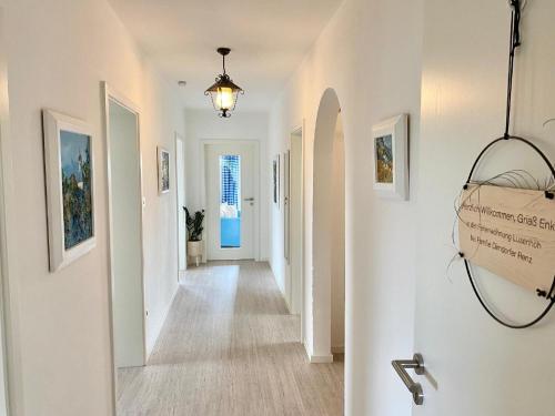 a hallway of a home with white walls and a chandelier at Ferienwohnung Lusenhöh in Mauth