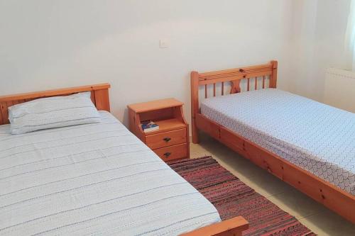 1 Schlafzimmer mit 2 Betten und einem Nachttisch in der Unterkunft Greek village life by the sea in Marathias