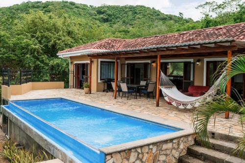a house with a swimming pool and a hammock at Exquisite Private Coastal Retreat home in San Juan del Sur