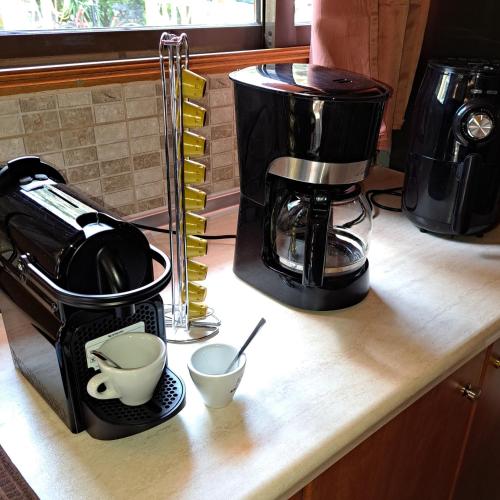 a counter with a coffee maker and cups on it at For Nature Lovers in Skala Rachoniou