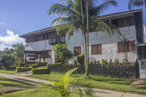a white house with a palm tree in front of it at Waira Selva Hotel in Puerto Nariño