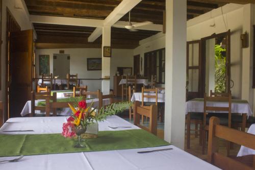 Puerto Nariño的住宿－Waira Selva Hotel，用餐室,配有鲜花桌