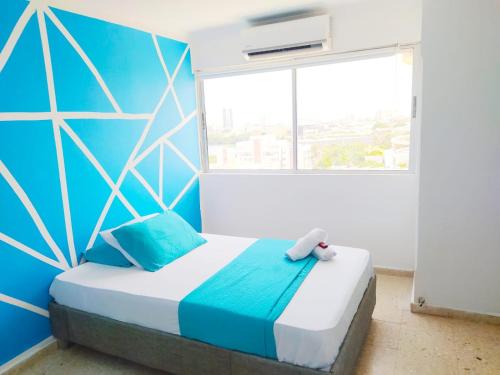 una camera con un letto con una parete blu di APT con vista al Mar - Cerca al Centro Histórico - 1106 a Cartagena de Indias