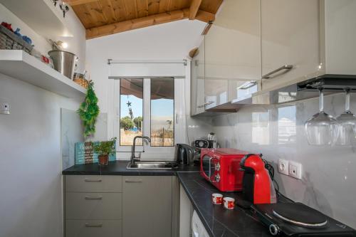 a kitchen with a red appliance on a counter at Marco Beach Tiny House in Faliraki
