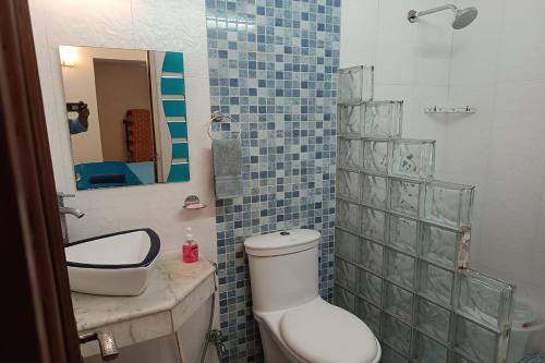a bathroom with a toilet and a sink and a mirror at Mintstar Apartment and Suites, East of Kailash in New Delhi