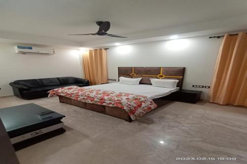 a bedroom with a large bed and a couch at Mintstar Apartment and Suites, East of Kailash in New Delhi