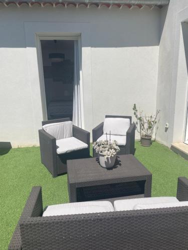 2 sillas y una mesa en un patio con césped en Suite 16m2 indépendante dans villa, en Manosque