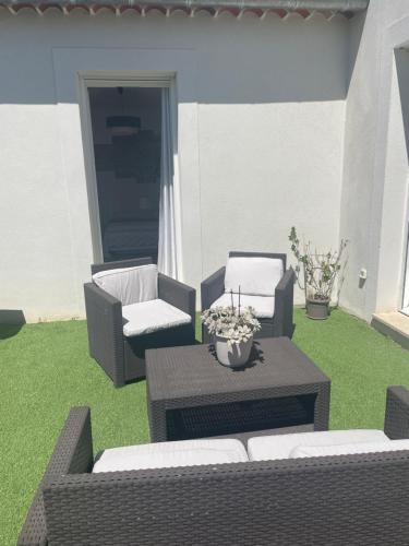 2 chaises et une table sur une terrasse avec pelouse dans l'établissement Suite 16m2 indépendante dans villa, à Manosque