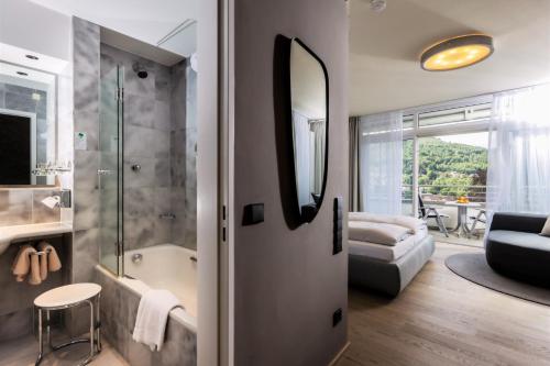 a bathroom with a shower and a tub and a bedroom at Schwarzwald Panorama in Bad Herrenalb
