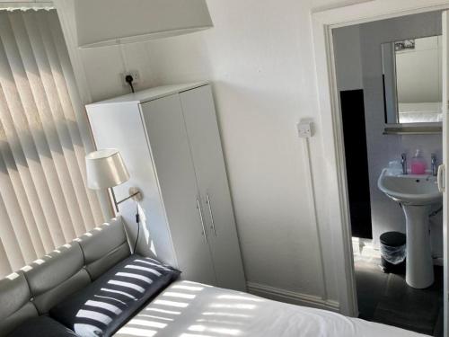 a bedroom with a bed and a sink and a mirror at The Hotel Blackpool in Blackpool