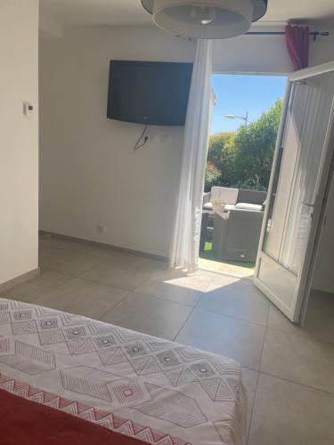 1 dormitorio con 1 cama y TV en la pared en Suite 16m2 indépendante dans villa, en Manosque