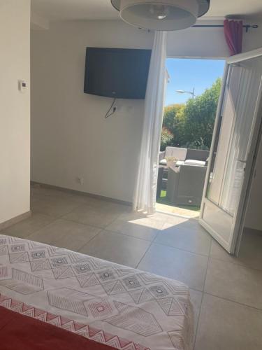 une chambre avec un lit et une télévision au mur dans l'établissement Suite 16m2 indépendante dans villa, à Manosque