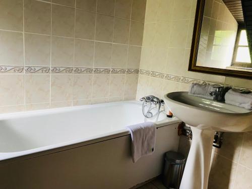 a bathroom with a sink and a white bath tub and a sink at Les Moulins Du Duc ÉCOLODGE in Moëlan-sur-Mer