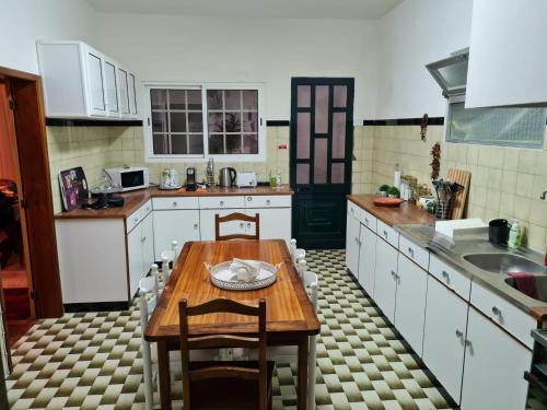 a kitchen with a wooden table and a sink at Villa Vista Norte in Porto Moniz