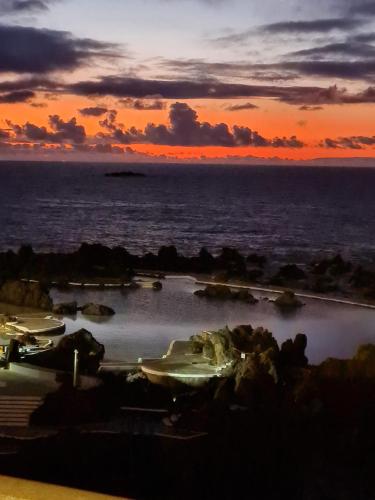a group of boats in the water at sunset at Villa Vista Norte in Porto Moniz