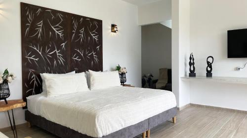 a bedroom with a bed with a black and white headboard at Aguas Claras Luxury Hospedaje in Filandia